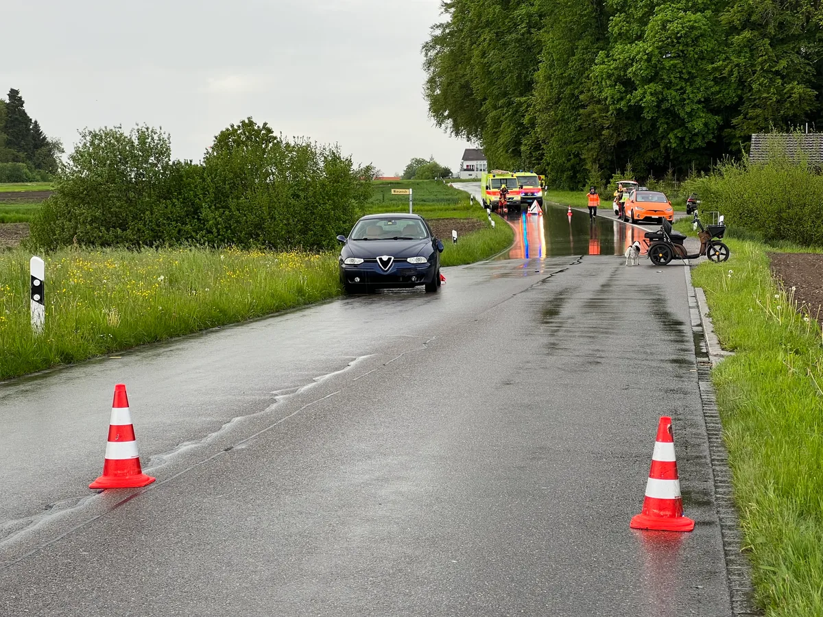 Das Bild zeigt eine Unfallstelle. Ein Auto steht am linken Strassenrand und ein Kyburzmotorfahrzeug am rechten.